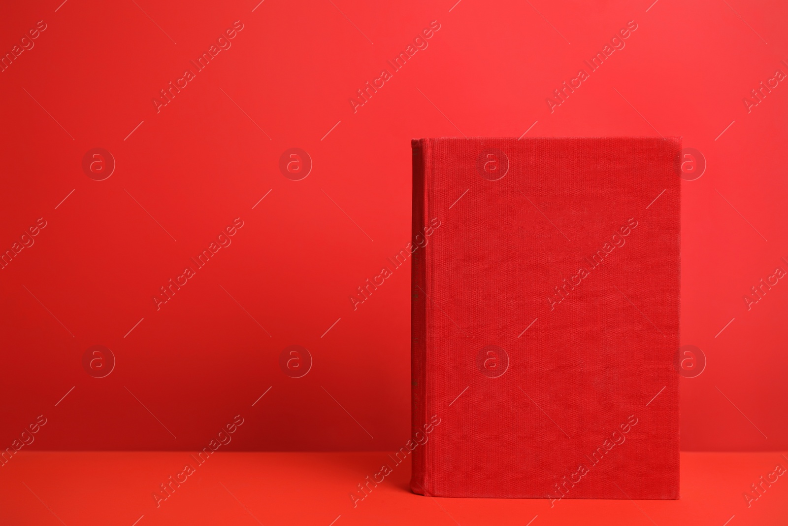Photo of Hardcover book on red background. Space for design