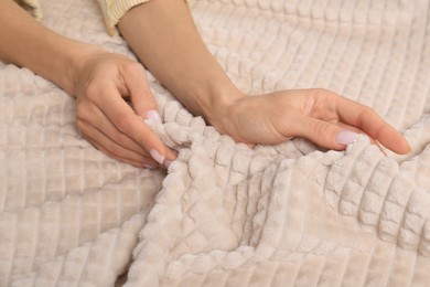Photo of Woman touching soft beige fabric, closeup view