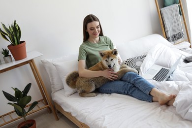 Happy woman with her cute Akita Inu puppy at home