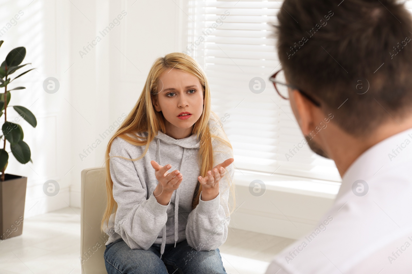 Photo of Psychotherapist working with drug addicted young woman indoors