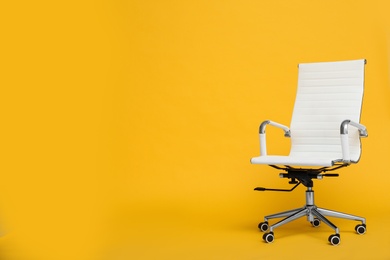 Modern office chair on yellow background. Space for text