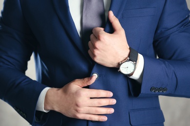 Photo of Man in formal suit with modern watch on light background, closeup