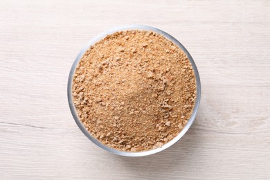 Photo of Fresh breadcrumbs in bowl on white wooden table, top view