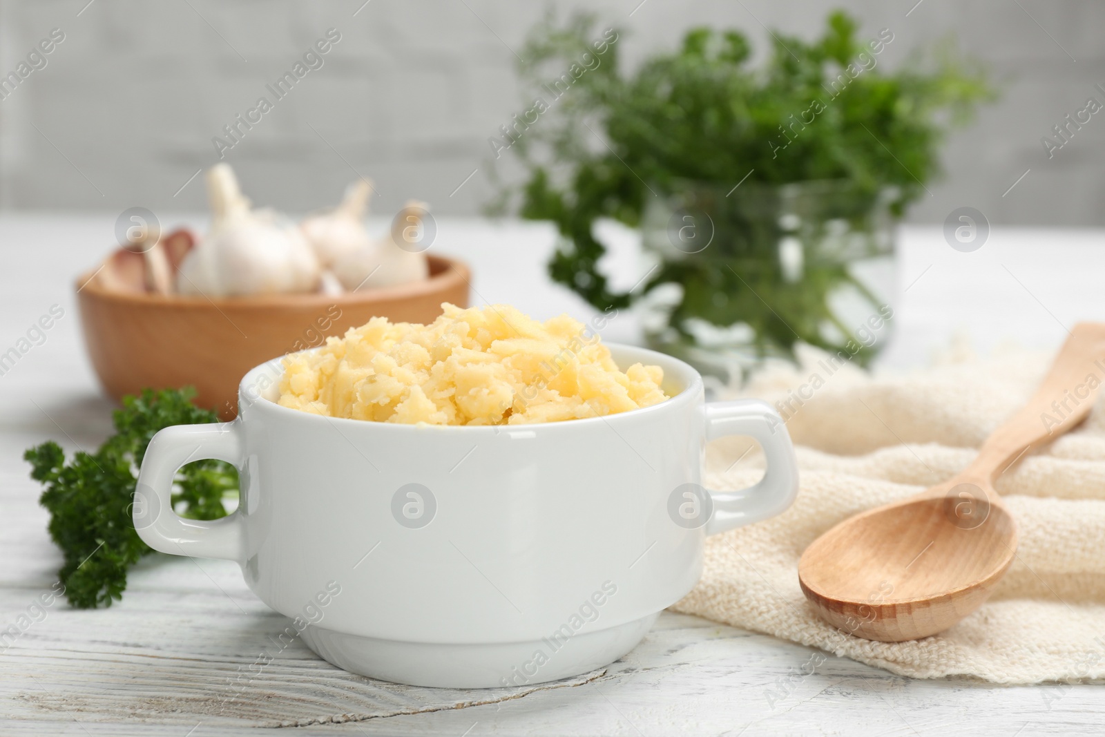 Photo of Bowl with mashed potatoes on wooden table