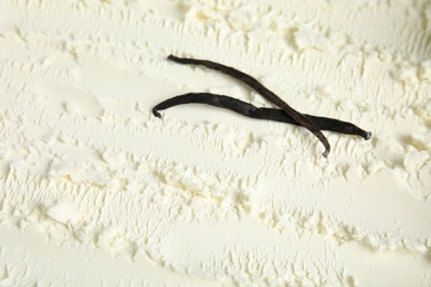 Photo of Vanilla pods and delicious ice cream as background, closeup. Space for text