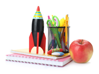 Photo of Bright toy rocket and school supplies on white background