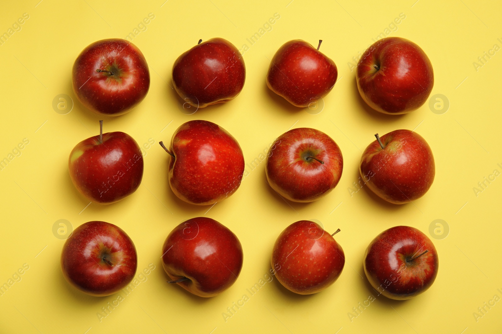 Photo of Flat lay composition with ripe juicy red apples on yellow background