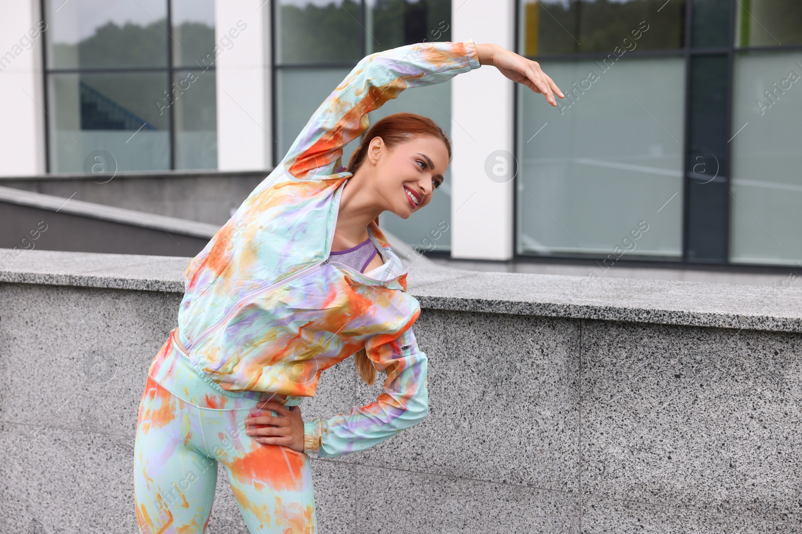 Photo of Beautiful woman in gym clothes doing exercises on street, space for text