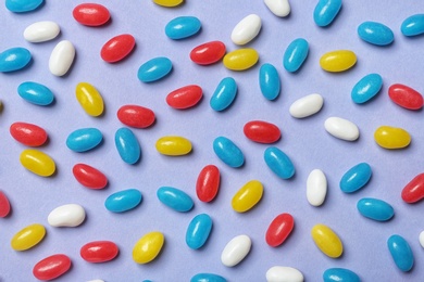 Many delicious jelly beans on color background, flat lay