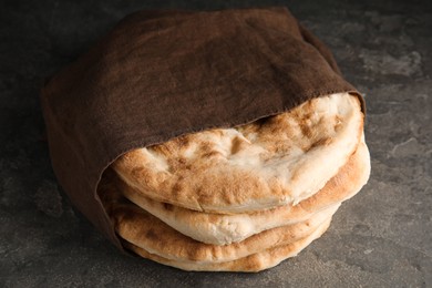 Photo of Delicious fresh pita bread and napkin on grey table