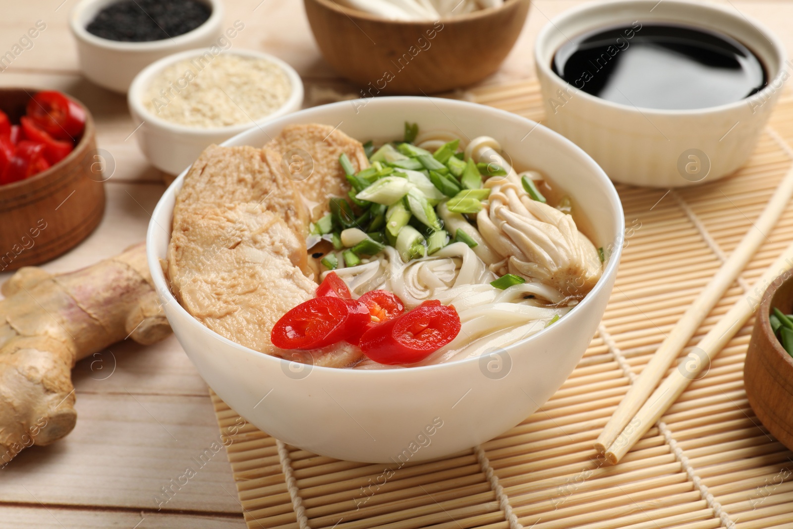 Photo of Delicious ramen with meat and ingredients on white wooden table, closeup. Noodle soup