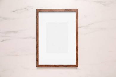 Photo of Empty photo frame on white marble background, top view. Space for design