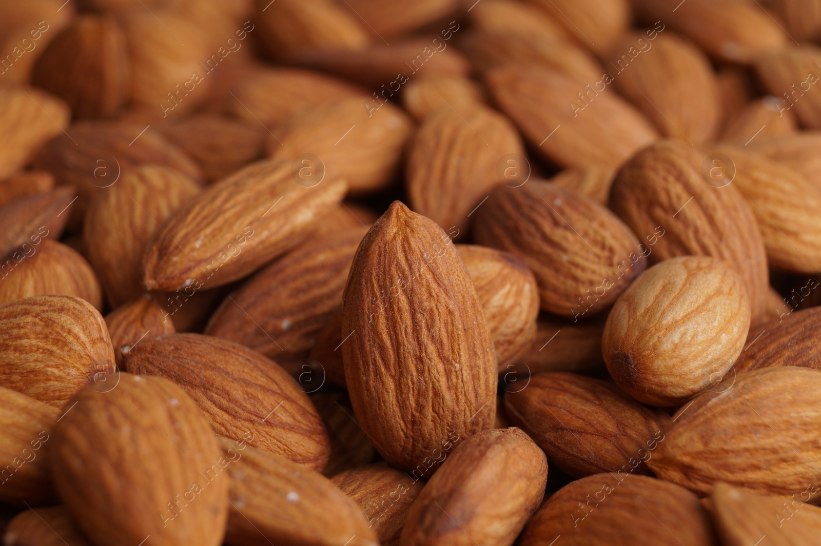 Photo of Pile of delicious raw ripe almonds, closeup