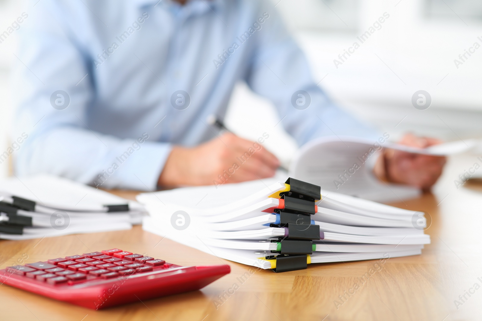 Photo of Businessman working at wooden table in office, focus on documents