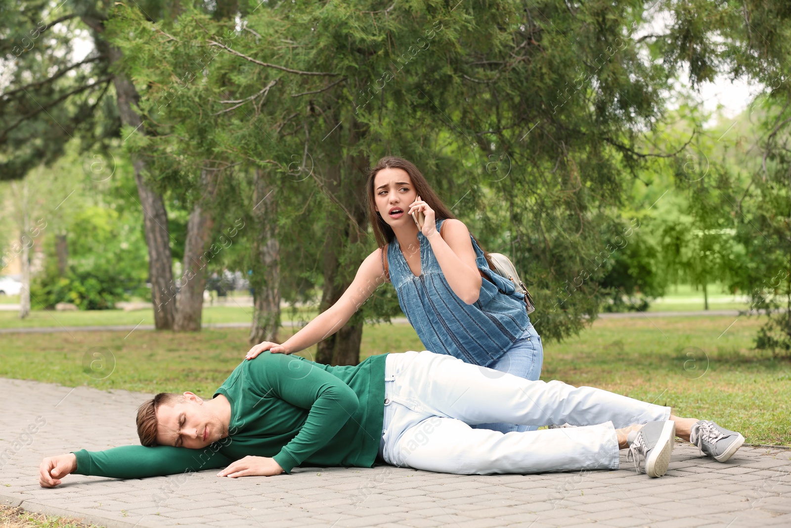 Photo of Passerby calling ambulance for man having heart attack outdoors