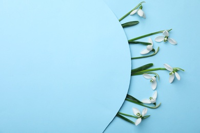 Beautiful snowdrops on turquoise background, flat lay. Space for text