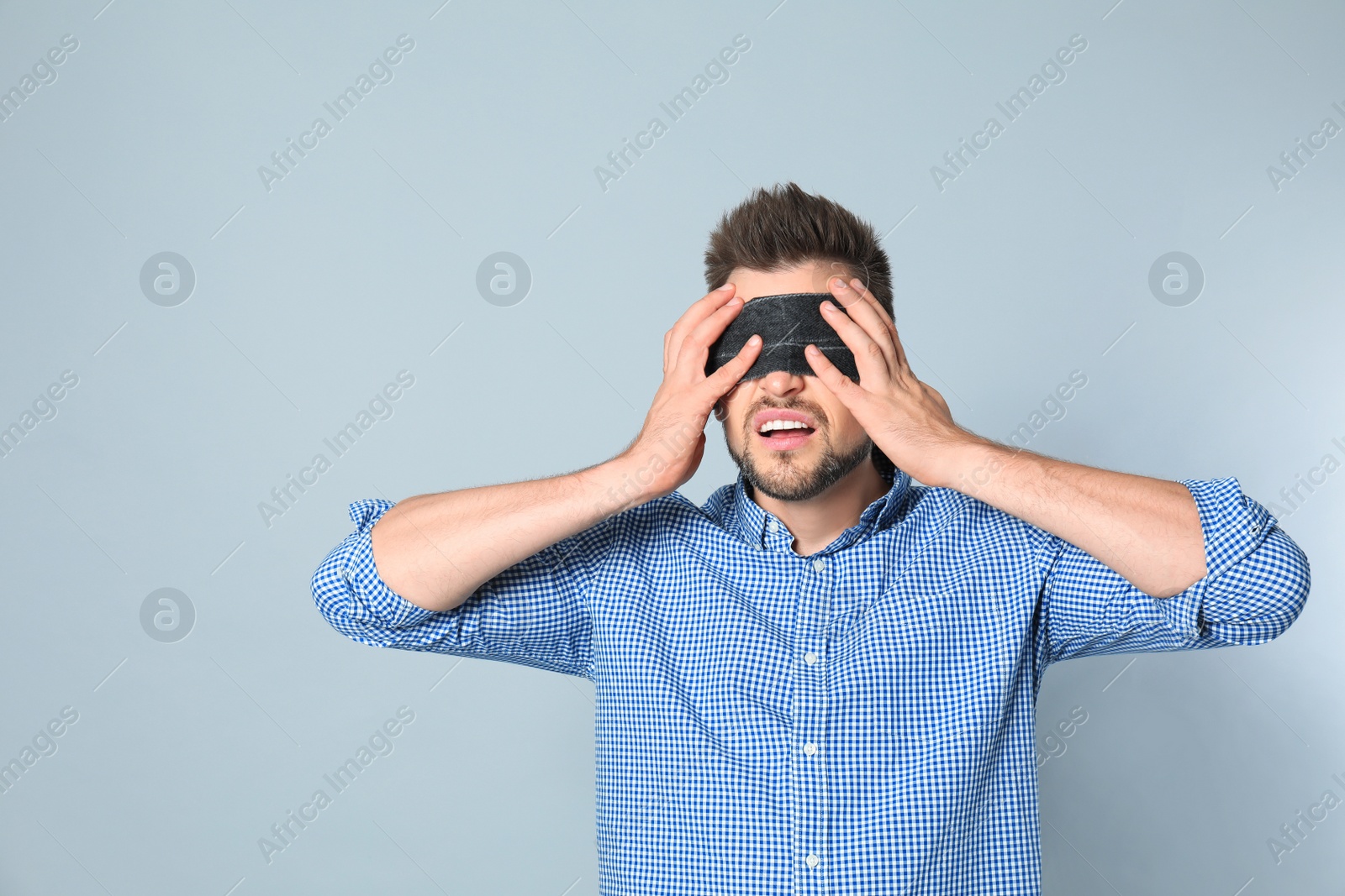 Photo of Man with black blindfold on grey background
