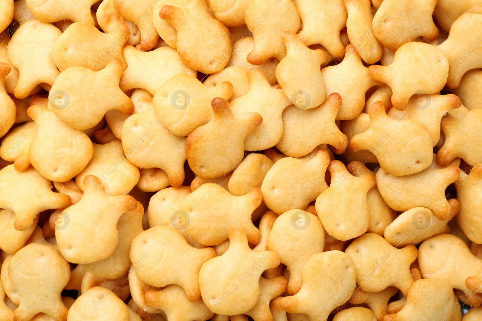 Photo of Delicious goldfish crackers as background, closeup view