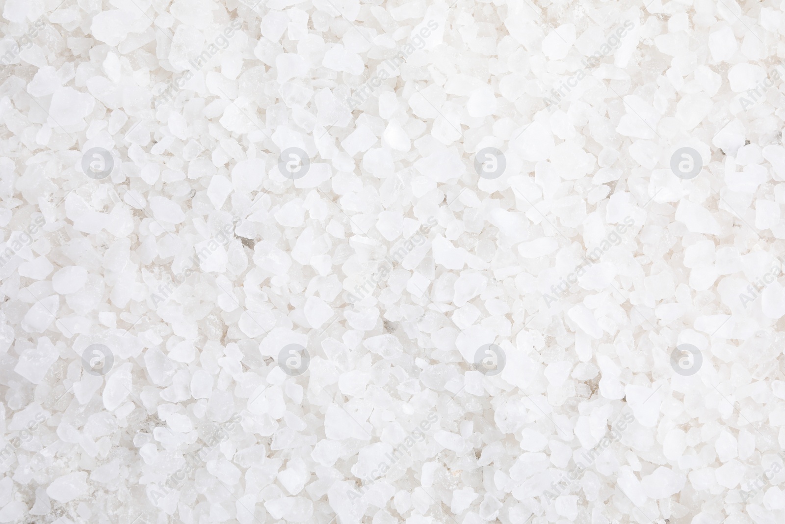 Photo of White sea salt as background, top view. Spa treatment