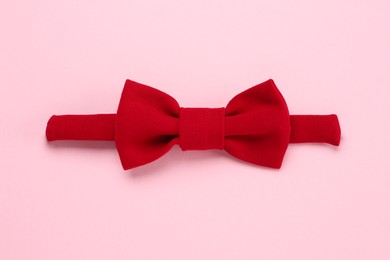 Photo of Stylish red bow tie on pink background, top view