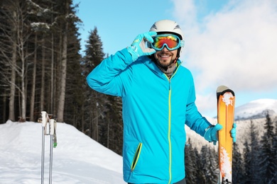 Man with ski equipment spending winter vacation in mountains