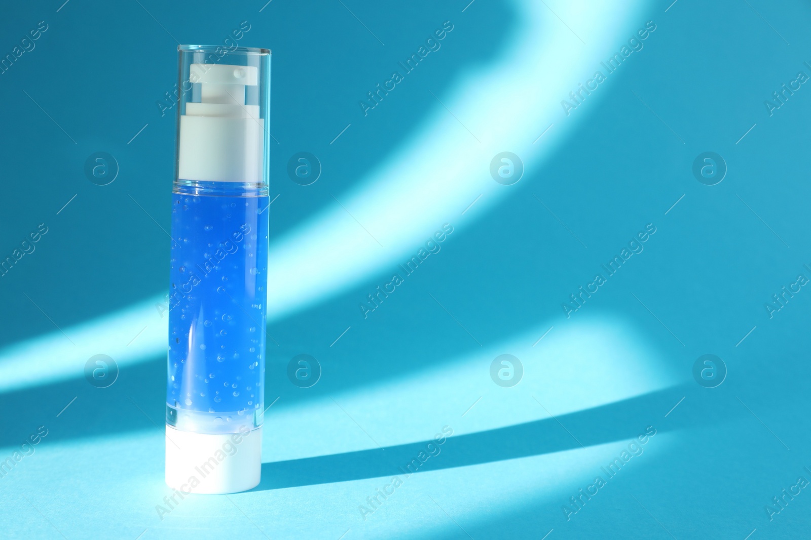 Photo of Bottle of cosmetic product on light blue background. Space for text