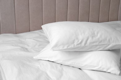 Photo of White soft pillows on bed. Space for text