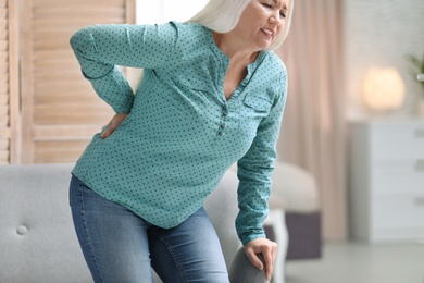 Photo of Senior woman suffering from back pain at home