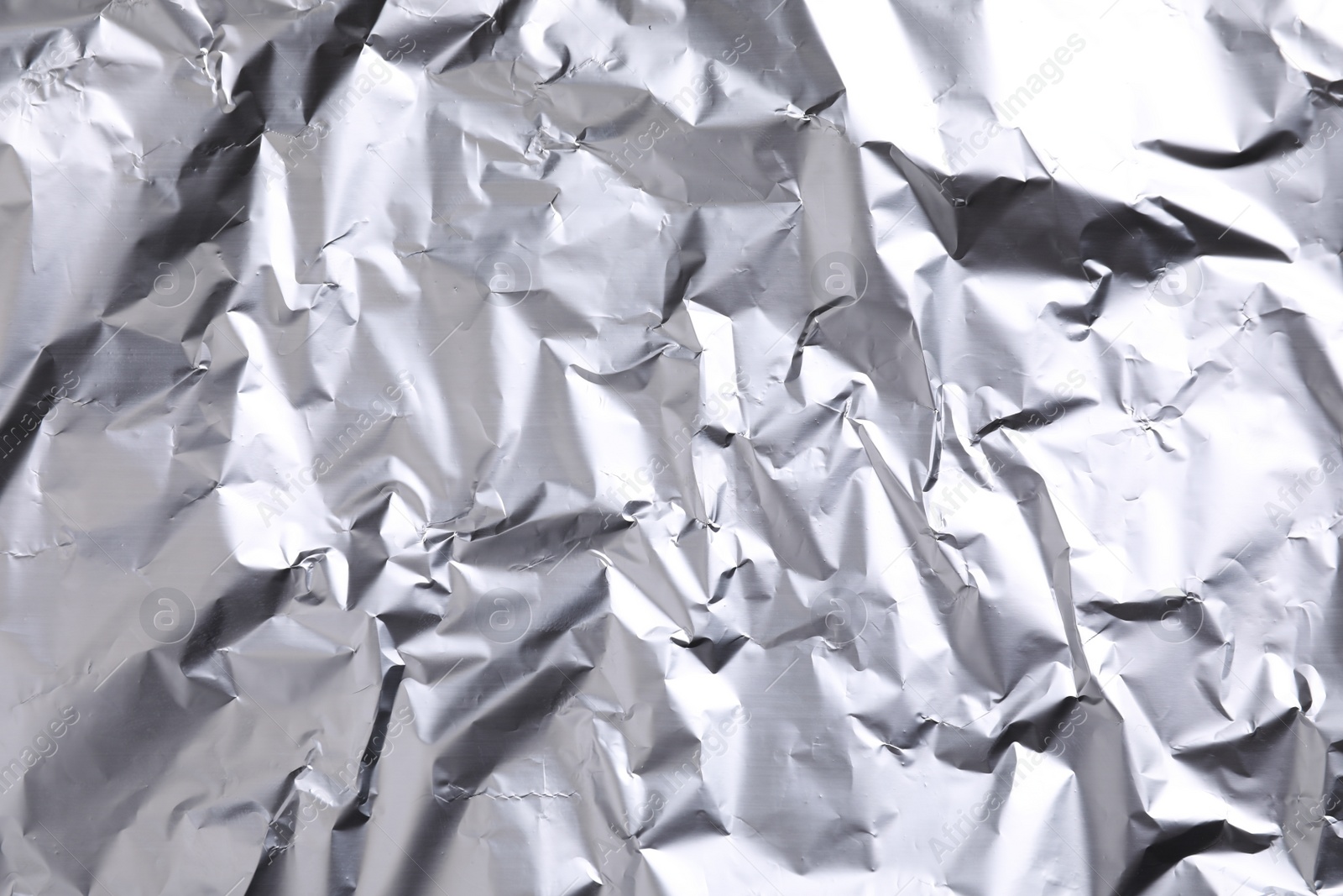 Photo of Crumpled silver foil as background, closeup view