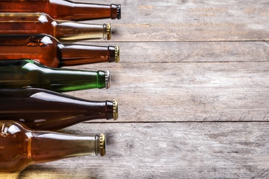 Photo of Bottles with different types of beer on wooden background