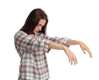 Photo of Young woman wearing pajamas in sleepwalking state on white background