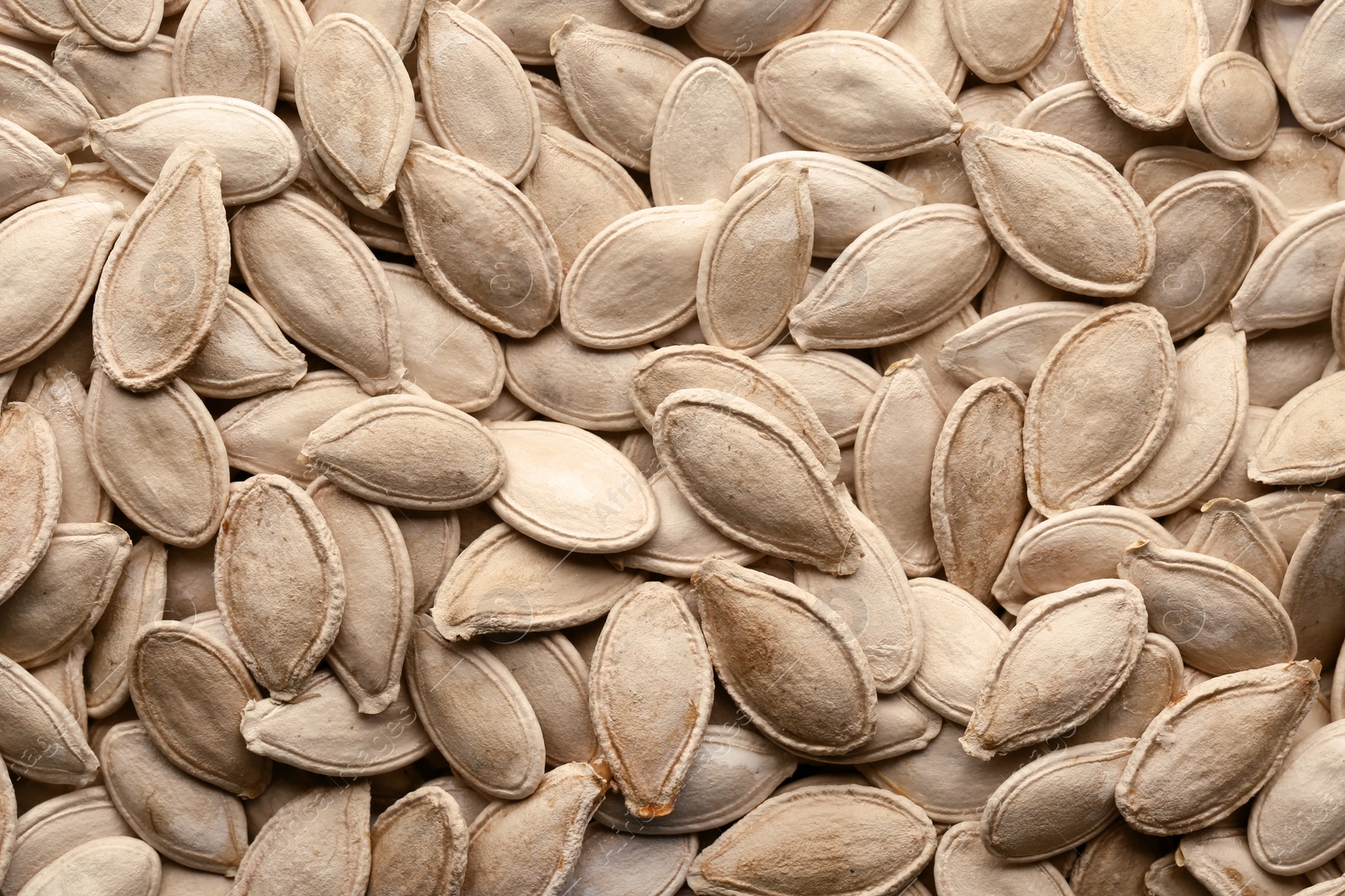 Photo of Raw pumpkin seeds as background, top view