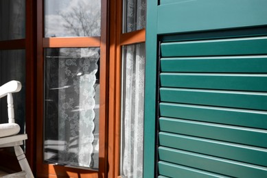 Photo of Window with vintage wooden shutters outdoors, closeup
