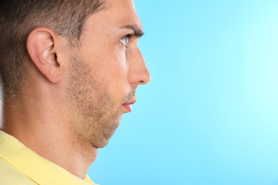 Young man with double chin on blue background. Space for text