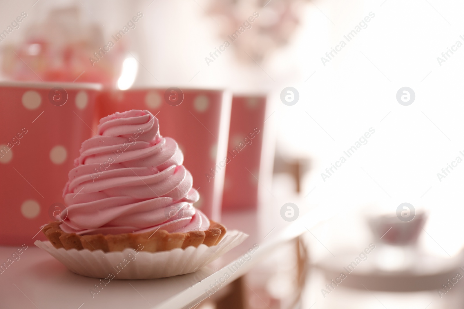 Photo of Delicious cake with pink cream for birthday party on white table, closeup. Space for text