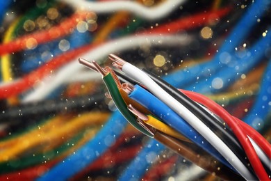 Image of Colorful electrical wires against blurred background, closeup. Bokeh effect