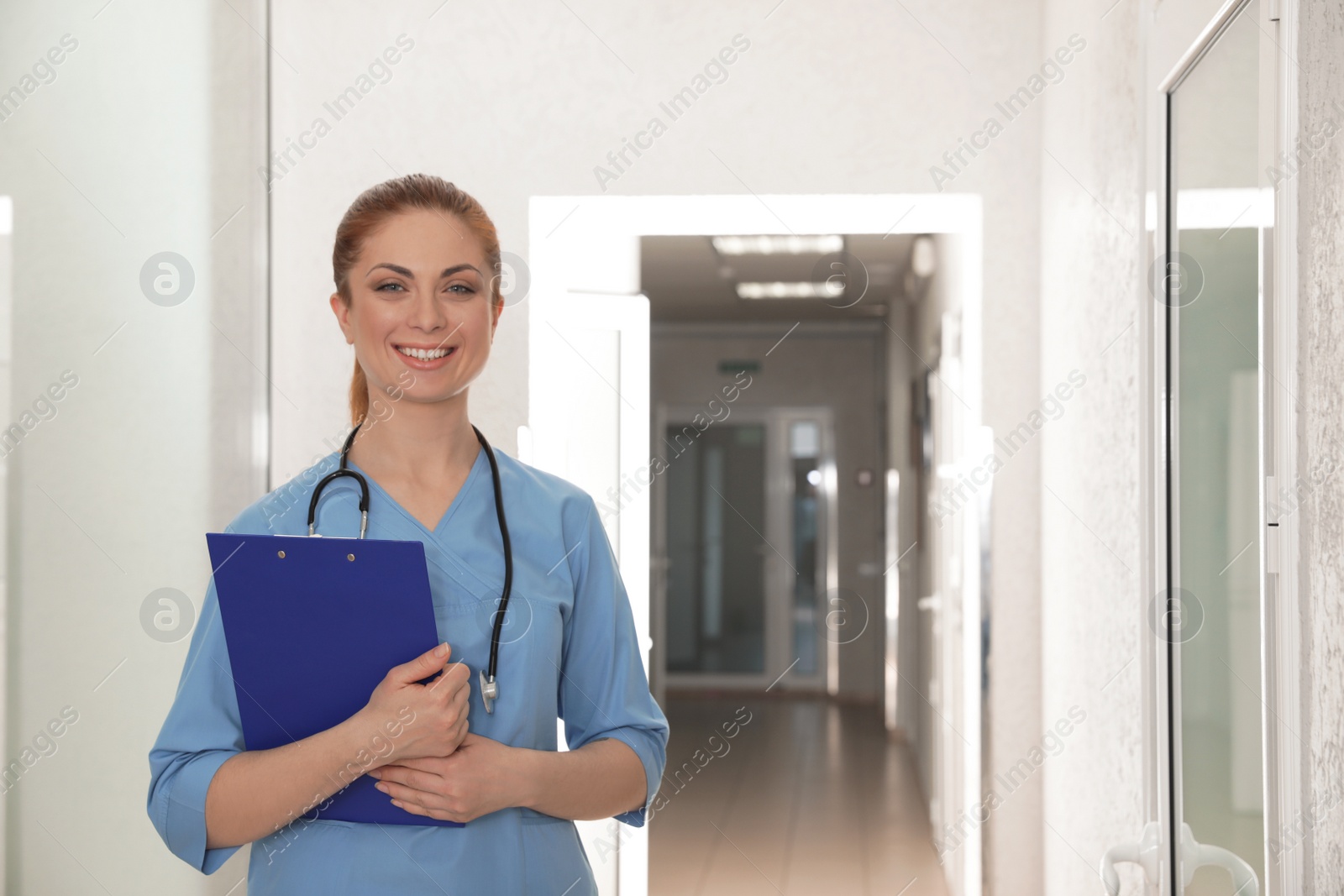 Photo of Portrait of nurse with clipboard in hospital hallway. Medical assisting