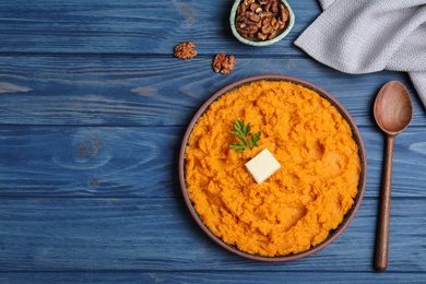 Flat lay composition with mashed sweet potatoes on wooden background, space for text