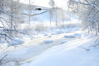 Photo of Picturesque view of frozen pond and trees covered with snow outdoors. Winter landscape