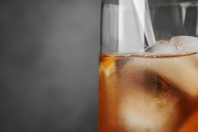 Photo of Glassware with refreshing iced tea on grey background, closeup. Space for text