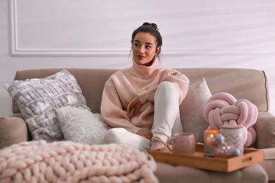 Beautiful young woman relaxing at home. Cozy atmosphere