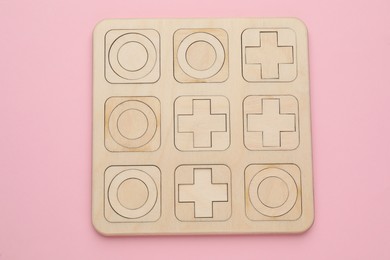 Photo of Tic tac toe set on pink background, top view