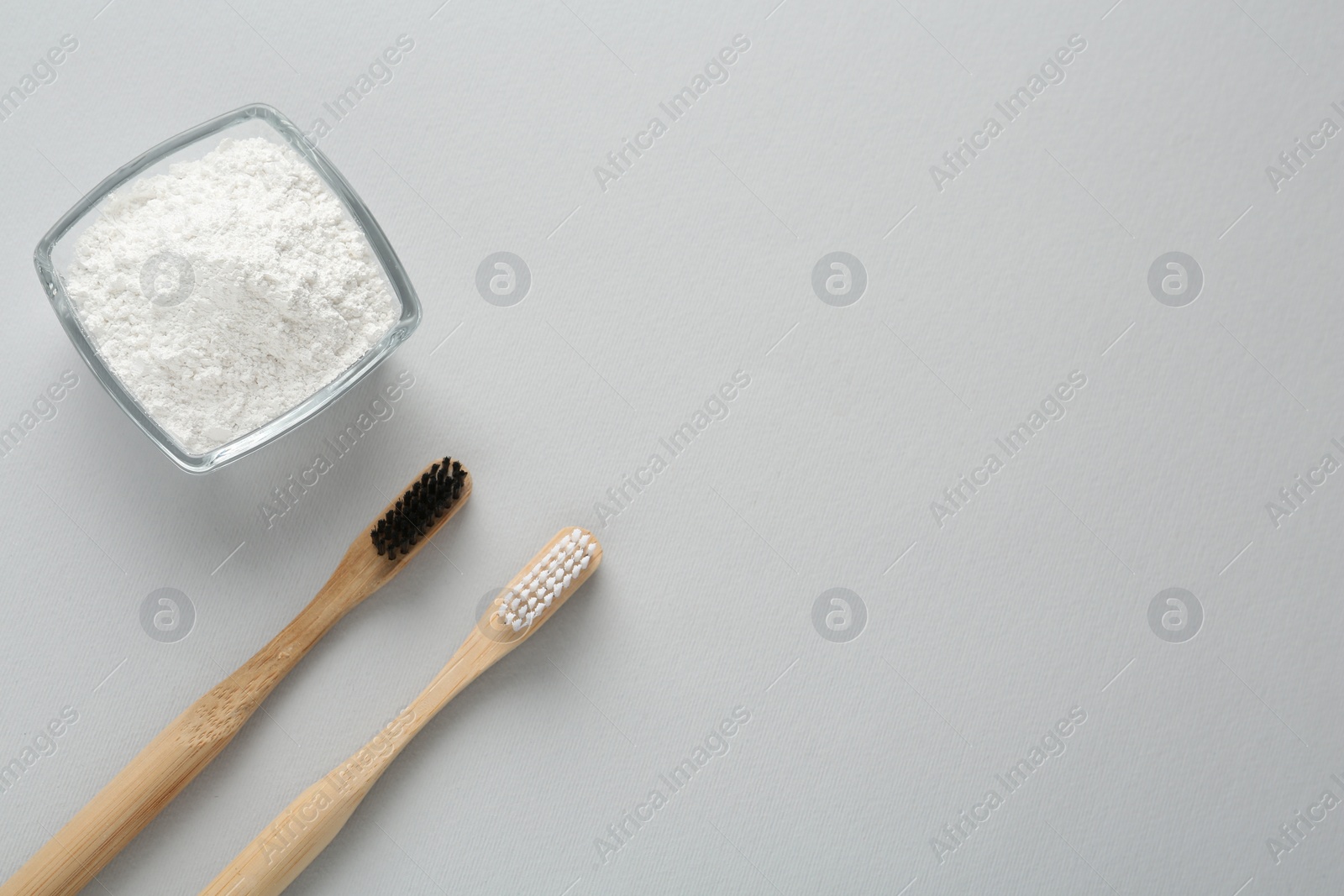 Photo of Tooth powder and brushes on white background, flat lay. Space for text