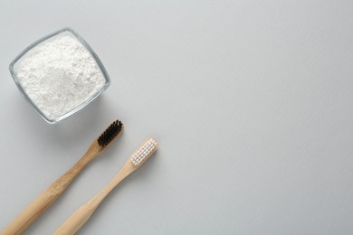 Tooth powder and brushes on white background, flat lay. Space for text