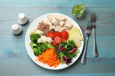 Photo of Balanced diet and healthy foods. Plate with different delicious products served on blue wooden table, top view