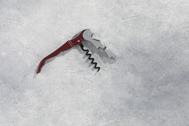 Photo of One corkscrew (sommelier knife) on grey textured table, top view. Space for text