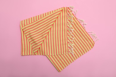 Photo of Folded striped beach towel on pink background, top view