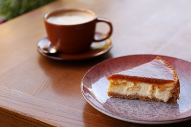 Photo of Plate with slice of cake on wooden table