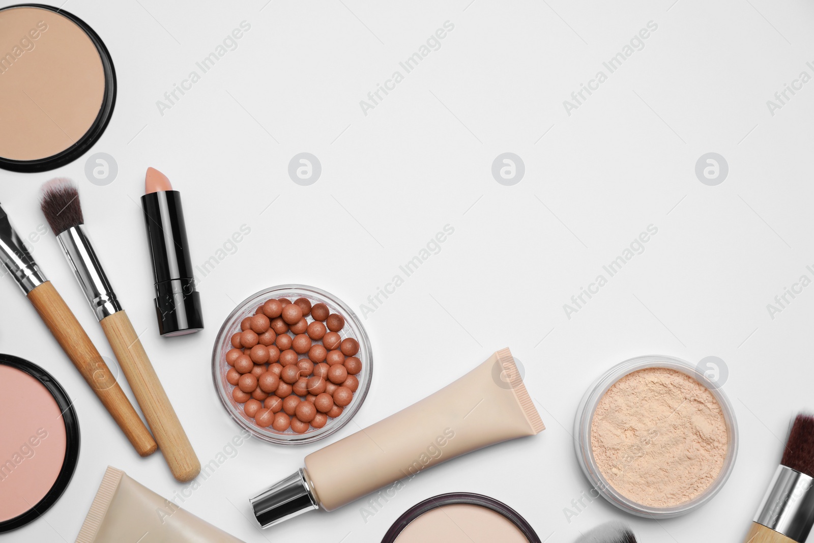 Photo of Face powders and other makeup products on white background, flat lay. Space for text