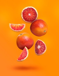 Image of Many tasty Sicilian oranges falling on bright orange background